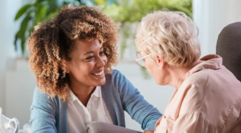 A care worker and client enjoying conversation together at home